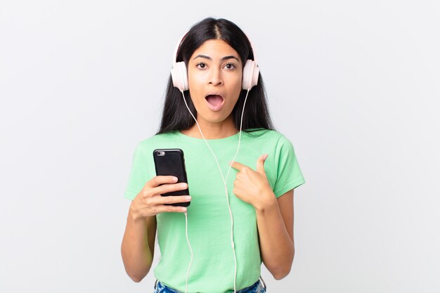 Hispanic pretty woman with headphones and a smarphone