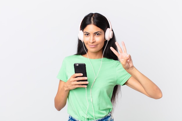 Hispanic pretty woman with headphones and a smarphone