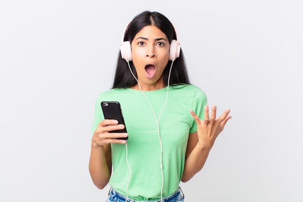 Hispanic pretty woman with headphones and smartphone