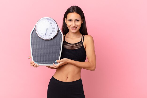 Hispanic pretty woman with a scale. diet concept