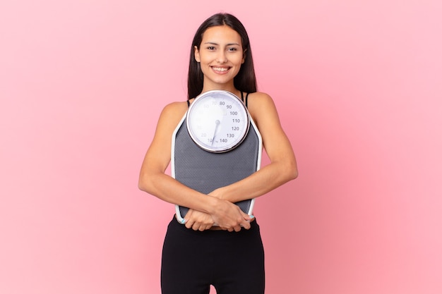 Hispanic pretty woman with a scale. diet concept