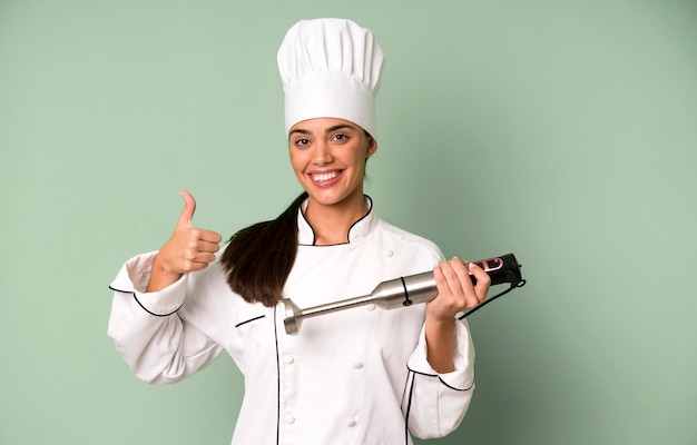 Hispanic pretty young adult and expressive woman chef concept and hand blender