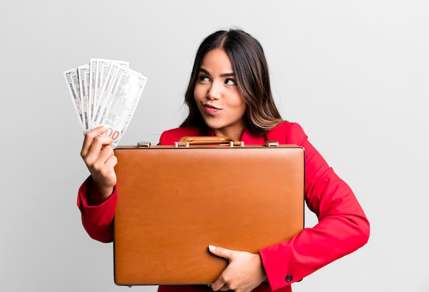 Hispanic pretty young adult woman with a suit case with banknotes