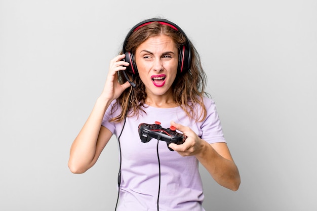 Испаноязычная симпатичная молодая женщина, играющая в наушниках и с концепцией контролирующего геймера