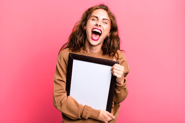 Hispanic pretty young woman with a blank frame copy space