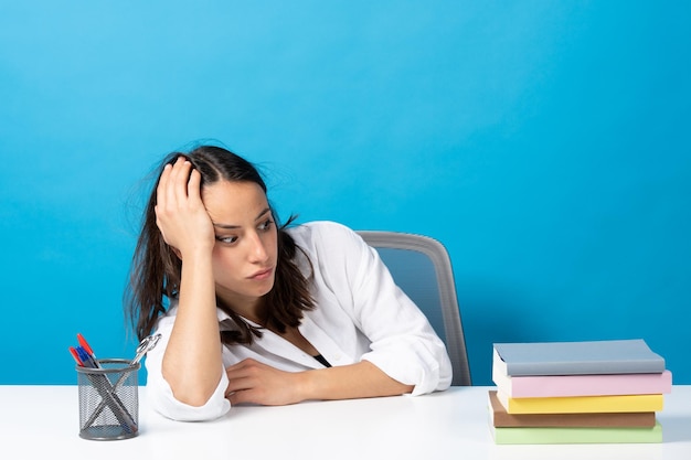 Hispanic student looking at pile of books