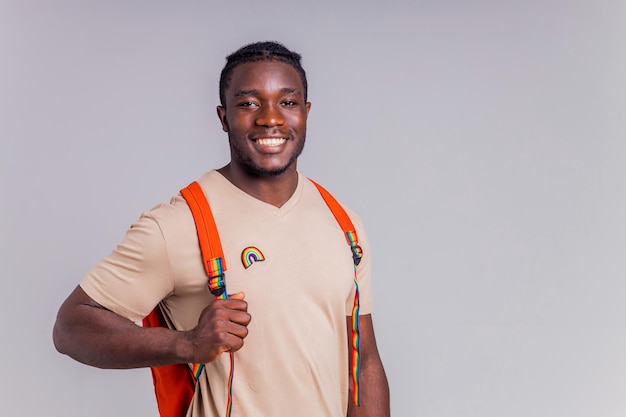 Hispanic student man with rainbow badge on tshirt in studio isolate