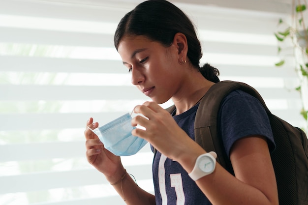 Hispanic student Putting Mask On Face