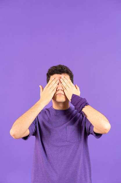 Hispanic teenager boy covering eyes with copy space