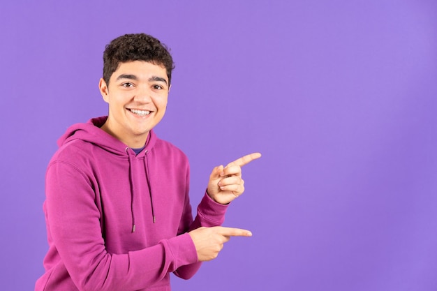 Hispanic teenager boy showing purple copy space