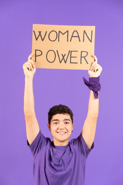 Hispanic teenager voy raising feminist billboard