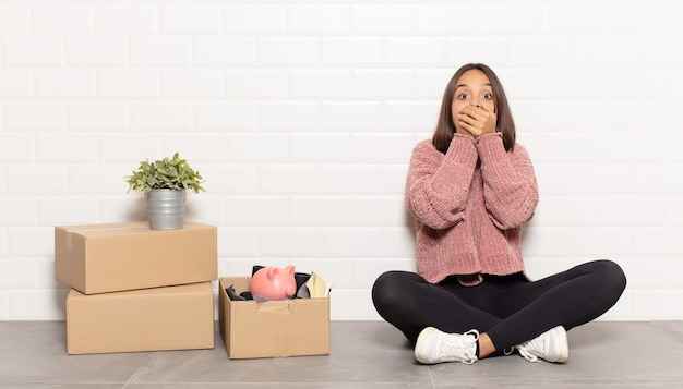 Hispanic woman covering mouth with hands with a shocked, surprised expression, keeping a secret or saying oops