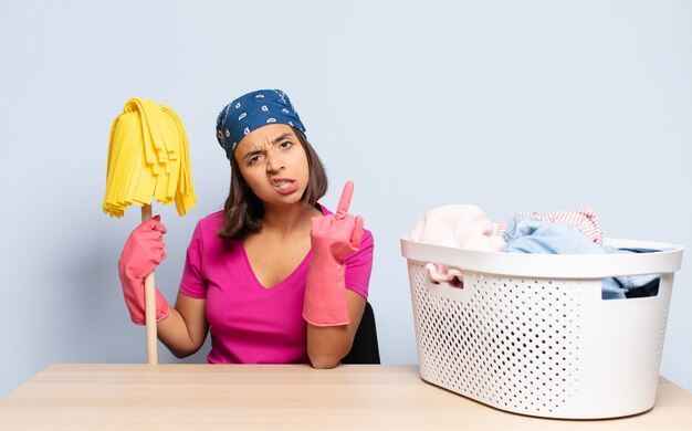 Hispanic woman feeling angry, annoyed, rebellious and aggressive, flipping the middle finger, fighting back