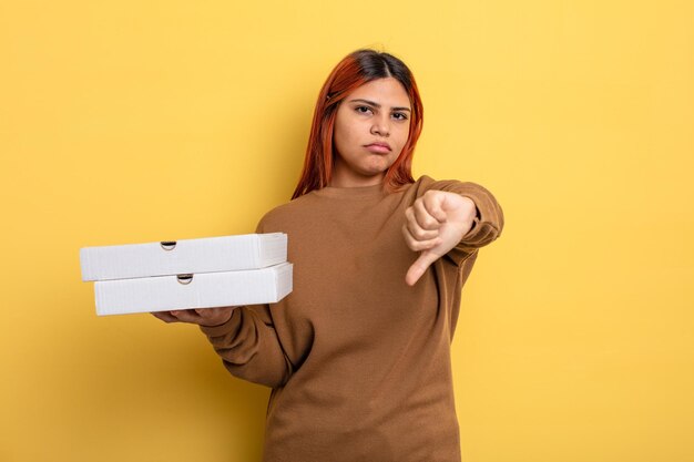 Hispanic woman feeling crossshowing thumbs down take away pizzas concept