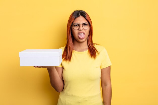 Hispanic woman feeling disgusted and irritated and tongue out. empty packaging concept