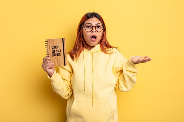 Hispanic woman feeling extremely shocked and surprised. recycle concept