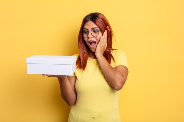 hispanic woman feeling happy, excited and surprised. empty packaging concept