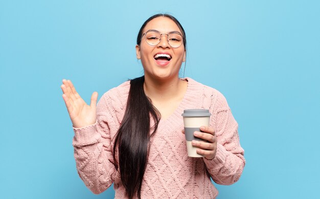 Hispanic woman feeling happy, excited, surprised or shocked, smiling and astonished at something unbelievable