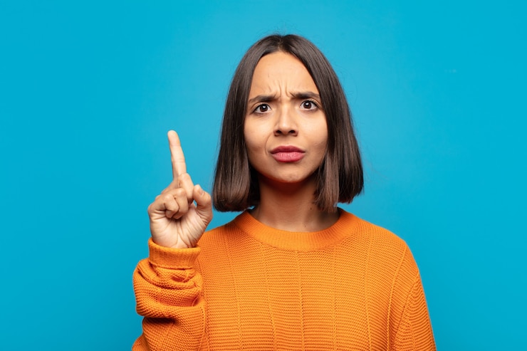 फोटो hispanic woman feeling like a genius holding finger proudly up in the air after realizing a great idea, saying eureka