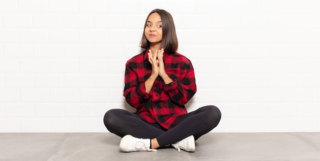 Hispanic woman feeling proud, mischievous and arrogant while scheming an evil plan or thinking of a trick