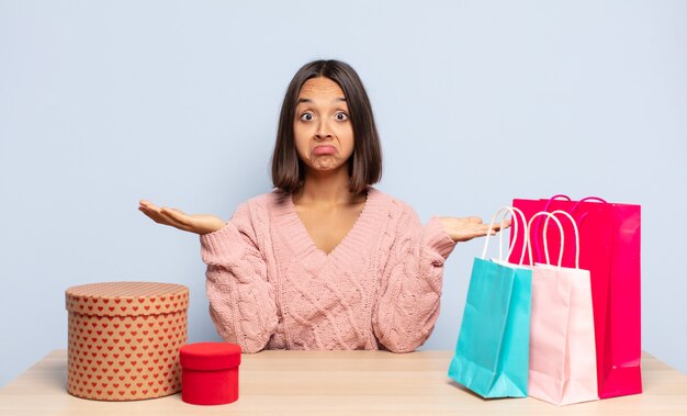 Hispanic woman feeling puzzled and confused, doubting, weighting or choosing different options with funny expression