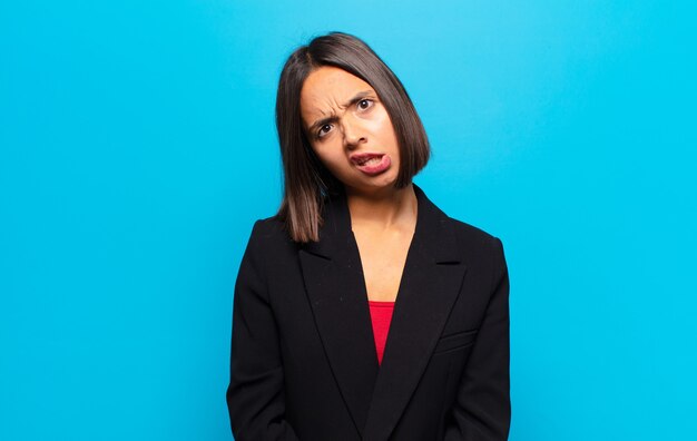 Hispanic woman feeling puzzled and confused, with a dumb, stunned expression looking at something unexpected