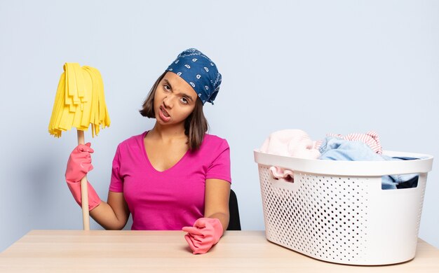 Hispanic woman feeling puzzled and confused, with a dumb, stunned expression looking at something unexpected