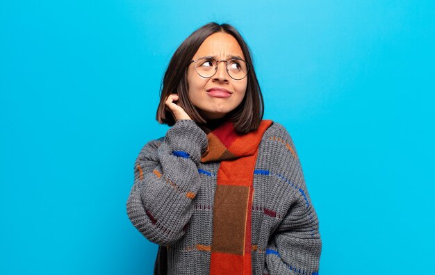 Hispanic woman feeling stressed, frustrated and tired, rubbing painful neck, with a worried, troubled look