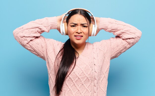 Hispanic woman feeling stressed, worried, anxious or scared, with hands on head, panicking at mistake