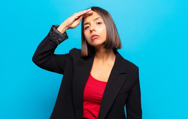 Hispanic woman greeting the camera with a military salute in an act of honor and patriotism, showing respect