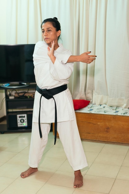 Hispanic Woman in kimono warming up before karate training