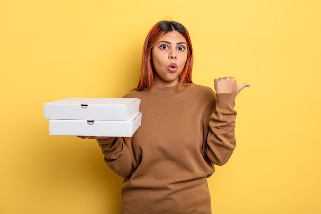 Hispanic woman looking astonished in disbelief. take away pizzas concept