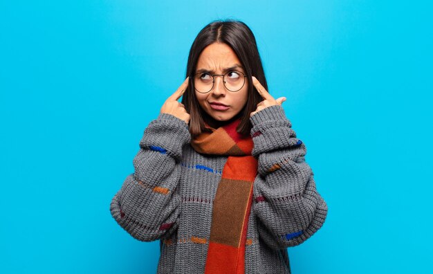 Hispanic woman looking concentrated and thinking hard on an idea, imagining a solution to a challenge or problem