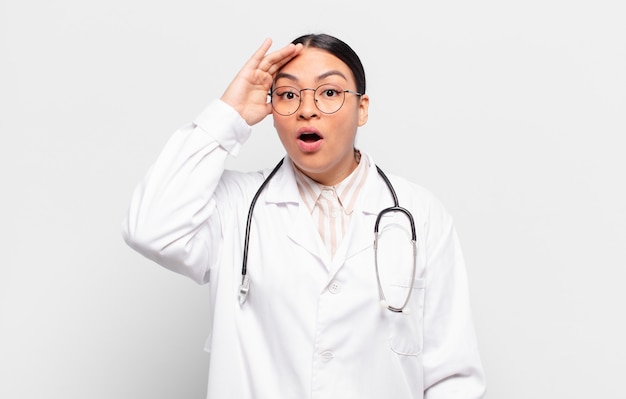 Hispanic woman looking happy, astonished and surprised, smiling and realizing amazing and incredible good news