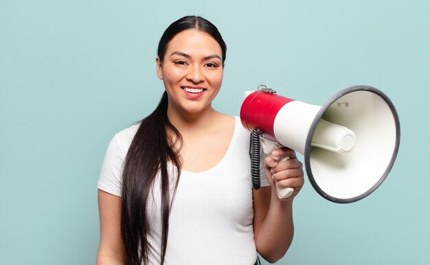 Hispanic woman looking happy and pleasantly surprised, excited with a fascinated and shocked expression