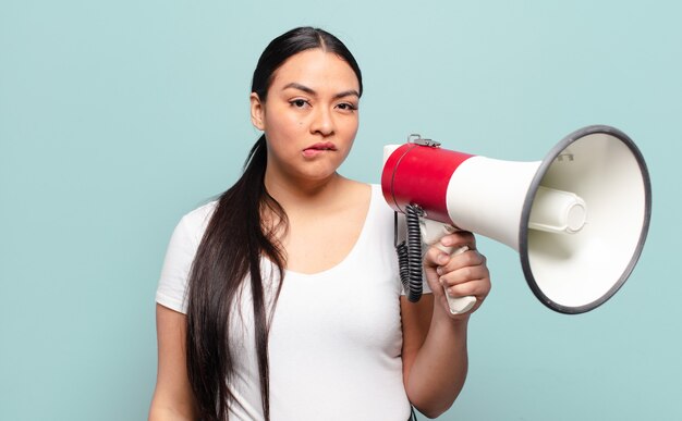 Hispanic woman looking puzzled and confused, biting lip with a nervous gesture, not knowing the answer to the problem