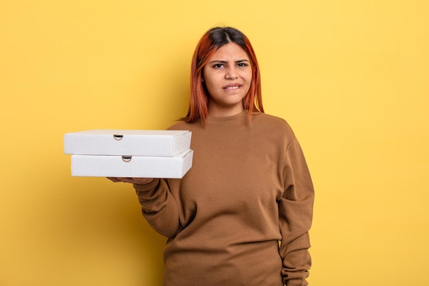 Hispanic woman looking puzzled and confused. take away pizzas concept