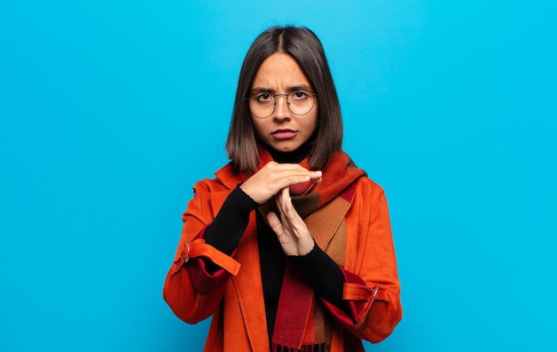 Hispanic woman looking serious, stern, angry and displeased, making time out sign