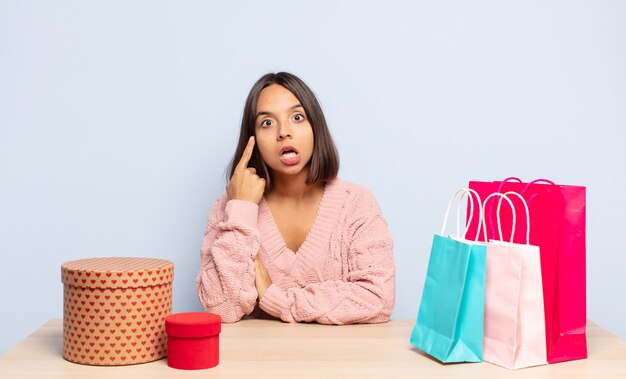 hispanic woman looking surprised, open-mouthed, shocked, realizing a new thought, idea or concept