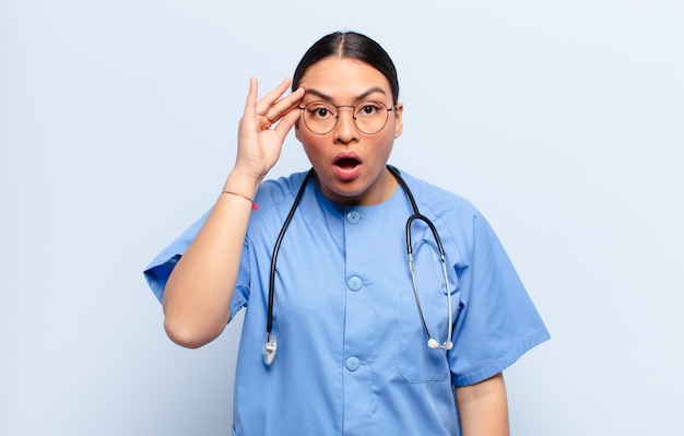 Hispanic woman looking surprised, open-mouthed, shocked, realizing a new thought, idea or concept