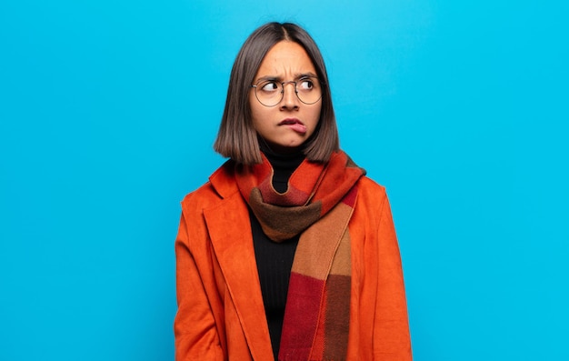 Hispanic woman looking worried, stressed, anxious and scared, panicking and clenching teeth