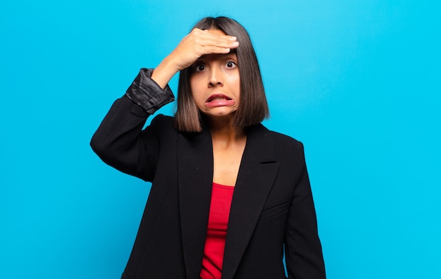 Hispanic woman panicking over a forgotten deadline, feeling stressed, having to cover up a mess or mistake