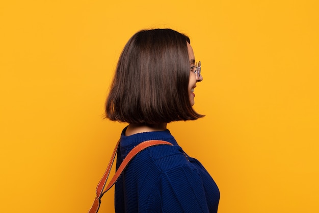 Hispanic woman on profile view looking to copy space ahead, thinking, imagining or daydreaming