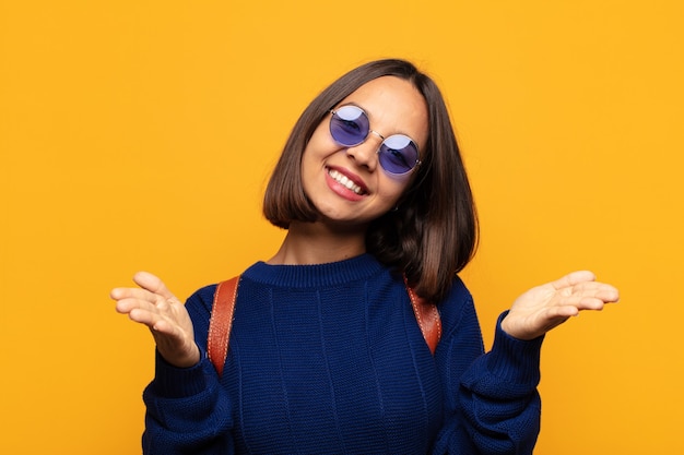 Hispanic woman smiling cheerfully giving a warm, friendly, loving welcome hug, feeling happy and adorable