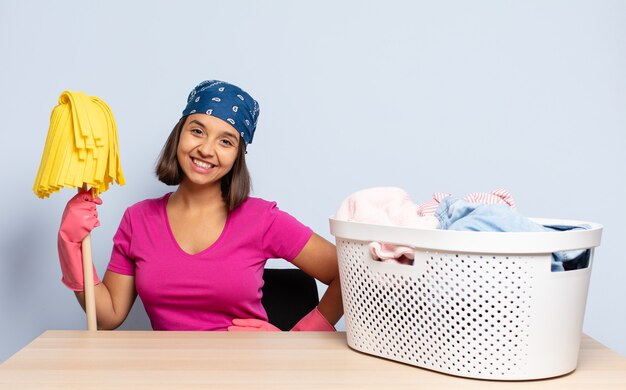 Hispanic woman smiling happily with a hand on hip and confident, positive, proud and friendly attitude