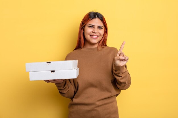 Hispanic woman smiling and looking friendly showing number one take away pizzas concept