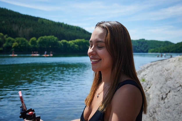 A Hispanic woman taking a selfie at the lake