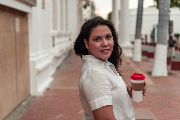 Hispanic Woman walking on the street with a backpack