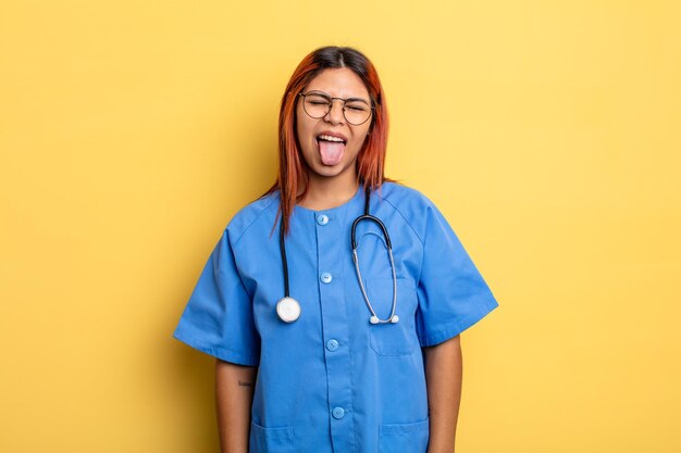 hispanic woman with cheerful and rebellious attitude, joking and sticking tongue out. nurse concept