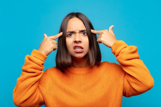 Photo hispanic woman with a serious and concentrated look, thinking about a challenging problem